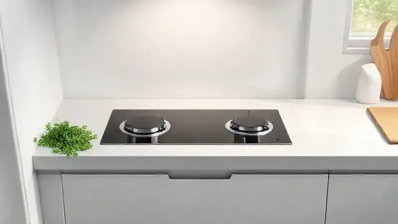 Ilustração de uma cozinha compacta moderna com um cooktop de 2 bocas embutido, focando na otimização de espaço.