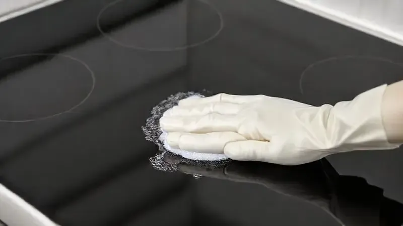 Render 3D mostrando a facilidade de limpeza de uma mesa de vidro de fogão, com uma mão limpando a superfície reflexiva.