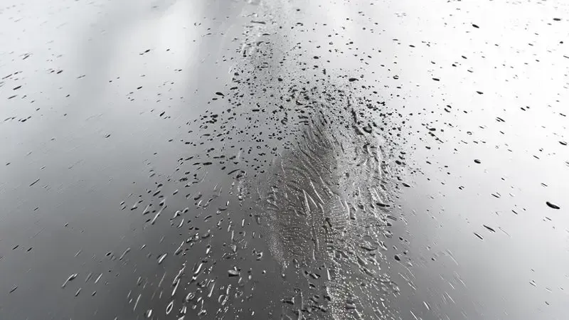 Superfície de aço inox mostrando transição entre área com marcas de dedos e água para área limpa e brilhante