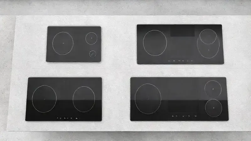 Render 3D mostrando diferentes tipos e tamanhos de cooktops de indução, como modelos de uma e quatro bocas, em uma bancada moderna.
