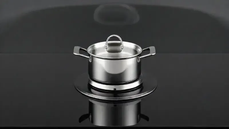 Render 3D conceitual de mesa de vidro temperado de fogão com pote sobre o queimador, simbolizando durabilidade e resistência a danos.